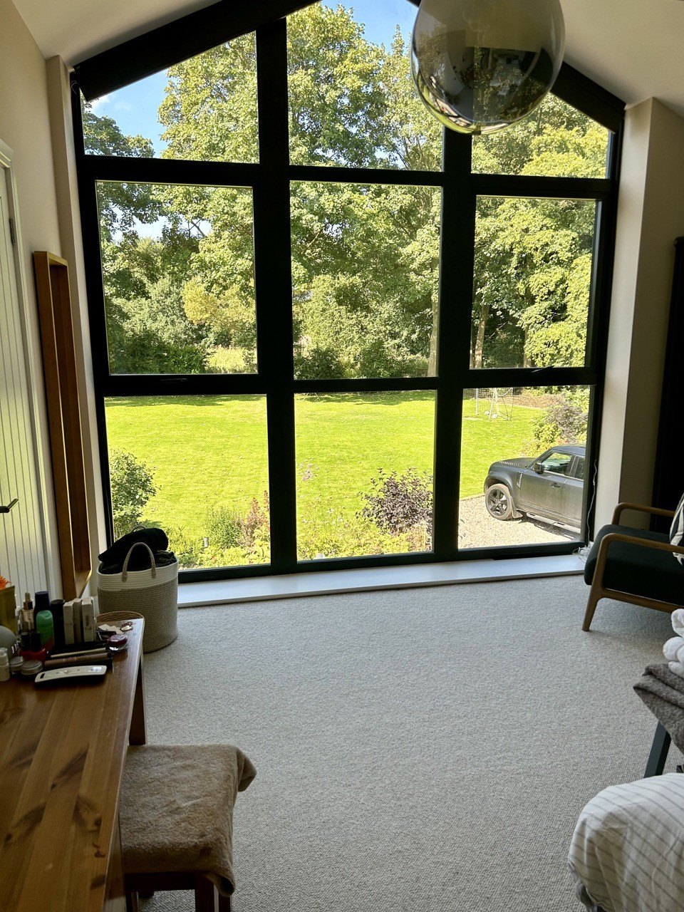 The view from a bedroom out through the black-framed glazed gable to the garden