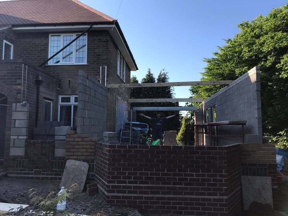 A 1930s house with the blockwork walls of a new side extension going up