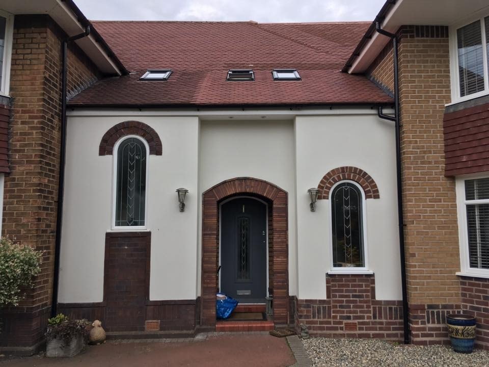 The finished side extension, rendered, with arched windows and an arched doorway matching the original house