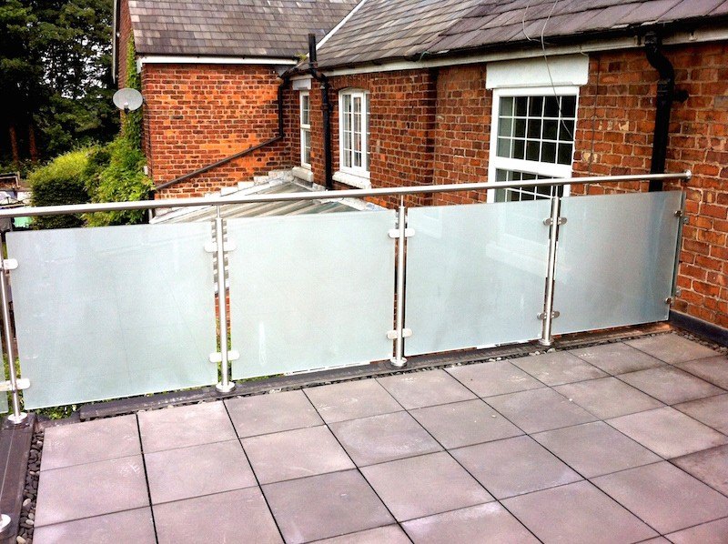 The roof terrace itself, paved, with a frosted glass balustrade